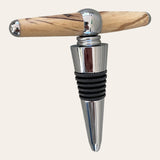 An Ambrosia Maple and metal wine stopper with a sleek T-shaped handle, crafted by Paul's Hand Turned Creations.