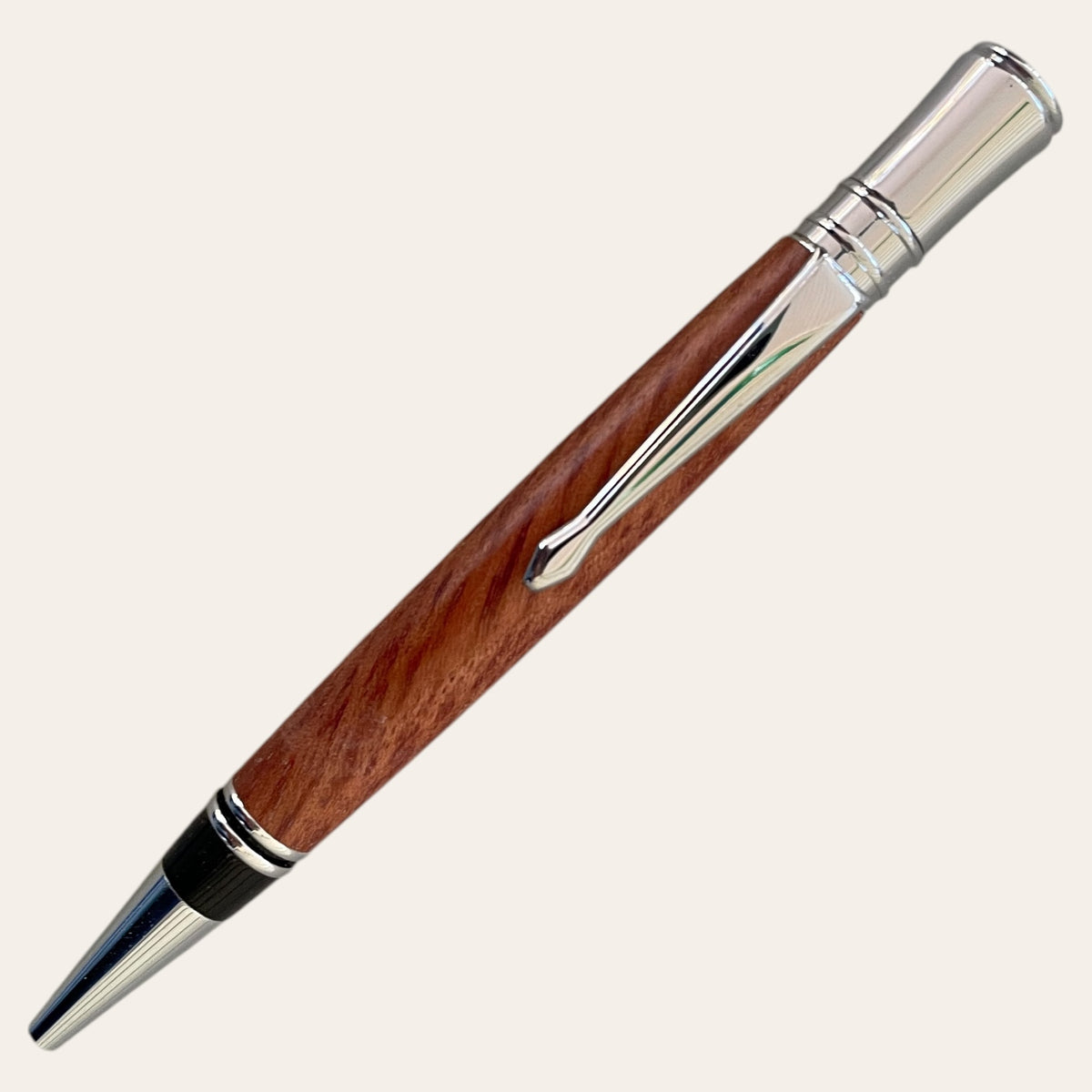 Bubinga Wood Pen with Chrome Accents by Paul's Hand Turned Creations on a plain background.