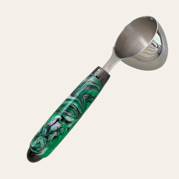 hand-turned coffee scoop called Evergreen forest with green, black and white swirl pattern on a chrome trim.
