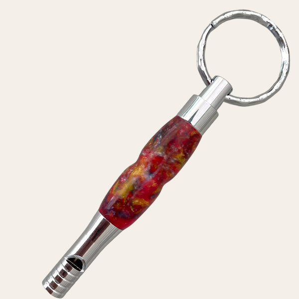 A unique accessory, the Resin Key Chain with Safety Whistle - Funky from Paul's Hand Turned Creations, boasts a colorful, marbled handle in shades of red, yellow, and green. It features a built-in safety whistle with a series of small grooves near the mouthpiece.