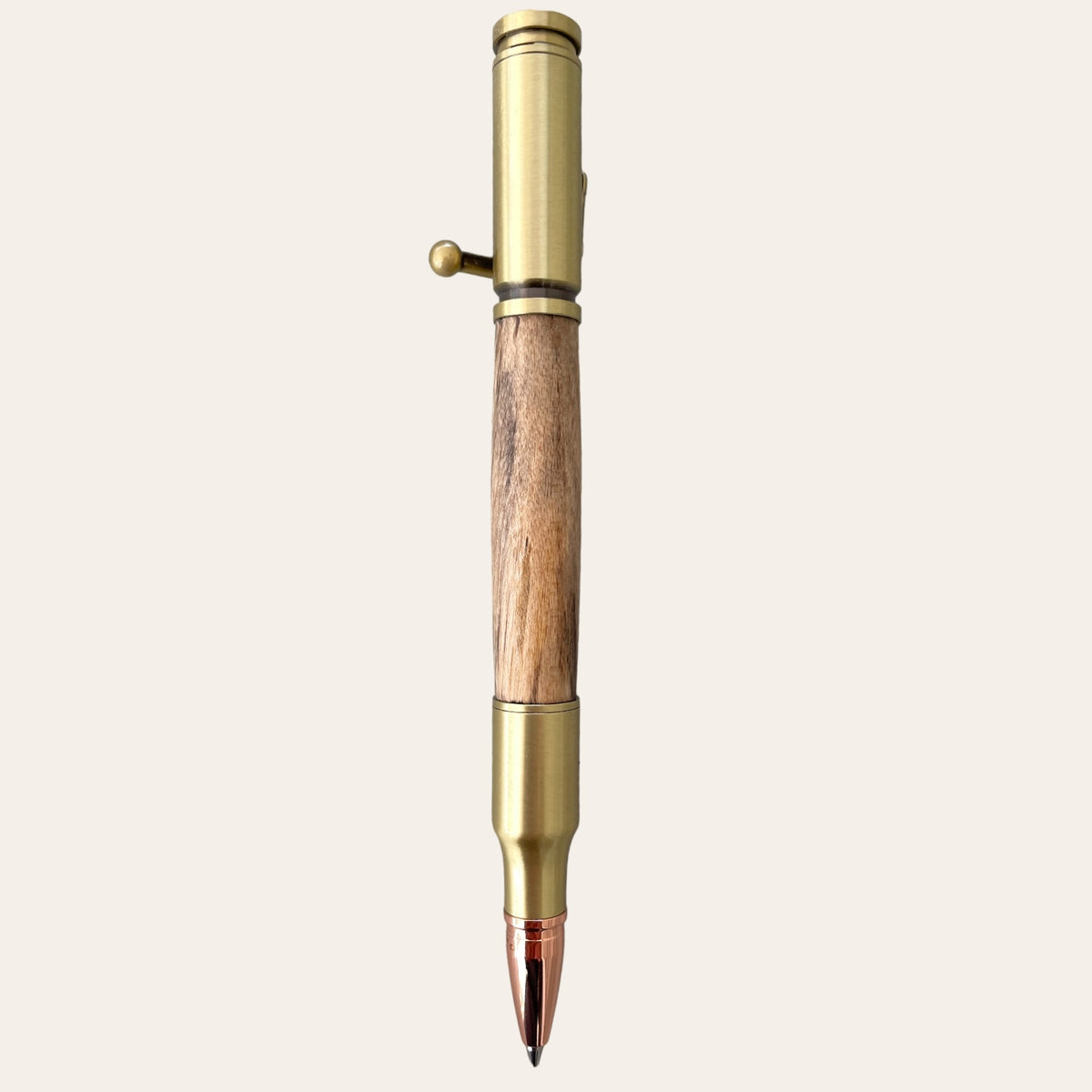 Paul's Hand Turned Creations offers a 30 Caliber Rifle Bolt Action Pen with Antique Brass and Spalted Maple Wood. This handcrafted pen is designed to resemble a rifle bullet, featuring an antique brass finish and a unique wooden grip. The metallic, vintage-inspired look is accentuated by a small lever near the top, showcasing meticulous craftsmanship. Hunting enthusiasts will particularly admire the darker metallic tip that provides it with a distinctive finishing touch.