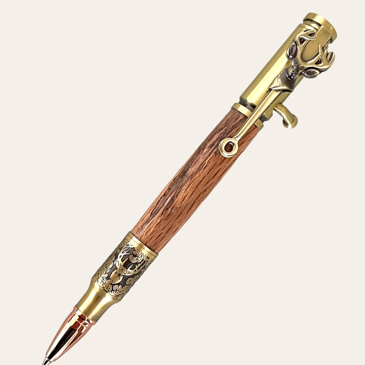 Introducing the Hand Turned Deer Hunter Bolt Action pen with an antique brass finish and laurel oak wood body, crafted by Paul's Hand Turned Creations. This luxurious, handmade pen features an ornate metal clip shaped like a deer, adding to its intricate and elegant design. The cap and tip are highlighted with an antique brass finish, giving it a sophisticated and vintage appearance.