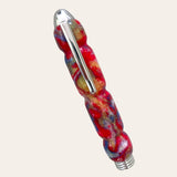 Introducing the Hand Turned Resin Case With Tweezer - Psychedelic from Paul's Hand Turned Creations. Featuring a vibrant red, blue, and yellow marbled pattern that radiates a psychedelic resin aesthetic, this acrylic pen boasts a chrome clip on its side and silver-colored ends. The barrel is intricately sculpted with a unique, textured design for an added touch of sophistication.