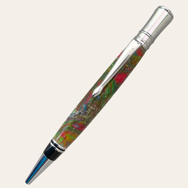 Introducing the Refillable Resin Executive Pen With Chrome Trim - Mysterious from Paul's Hand Turned Creations. Featuring a vibrant marbled barrel in mesmerizing shades of green, red, and brown, this executive twist pen is accentuated with elegant chrome trims on the tip, clip, and cap. Equipped with a Parker-style refill for smooth writing performance against a neutral off-white background.