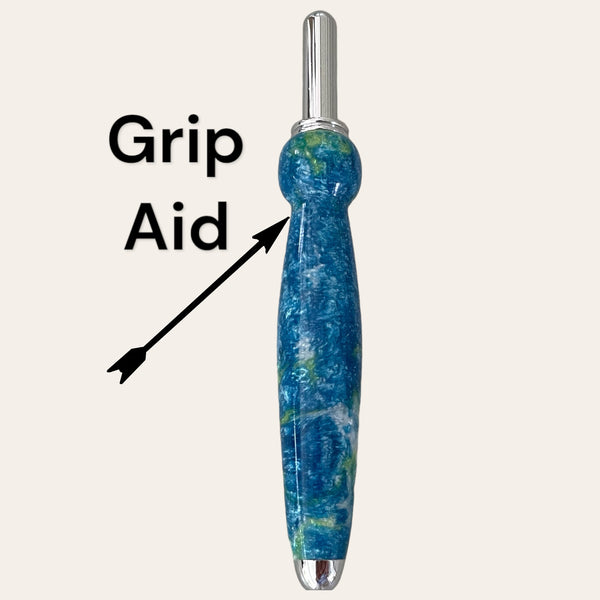 An image showcases a vibrant Under The Sea Resin Single Blade Seam Ripper, crafted by Paul's Hand Turned Creations, featuring a rounded body for comfortable handling. The label "Grip Aid" is displayed beside the tool with an arrow directed towards its midsection, indicating precision comparable to what you find in a fine-quality pen.