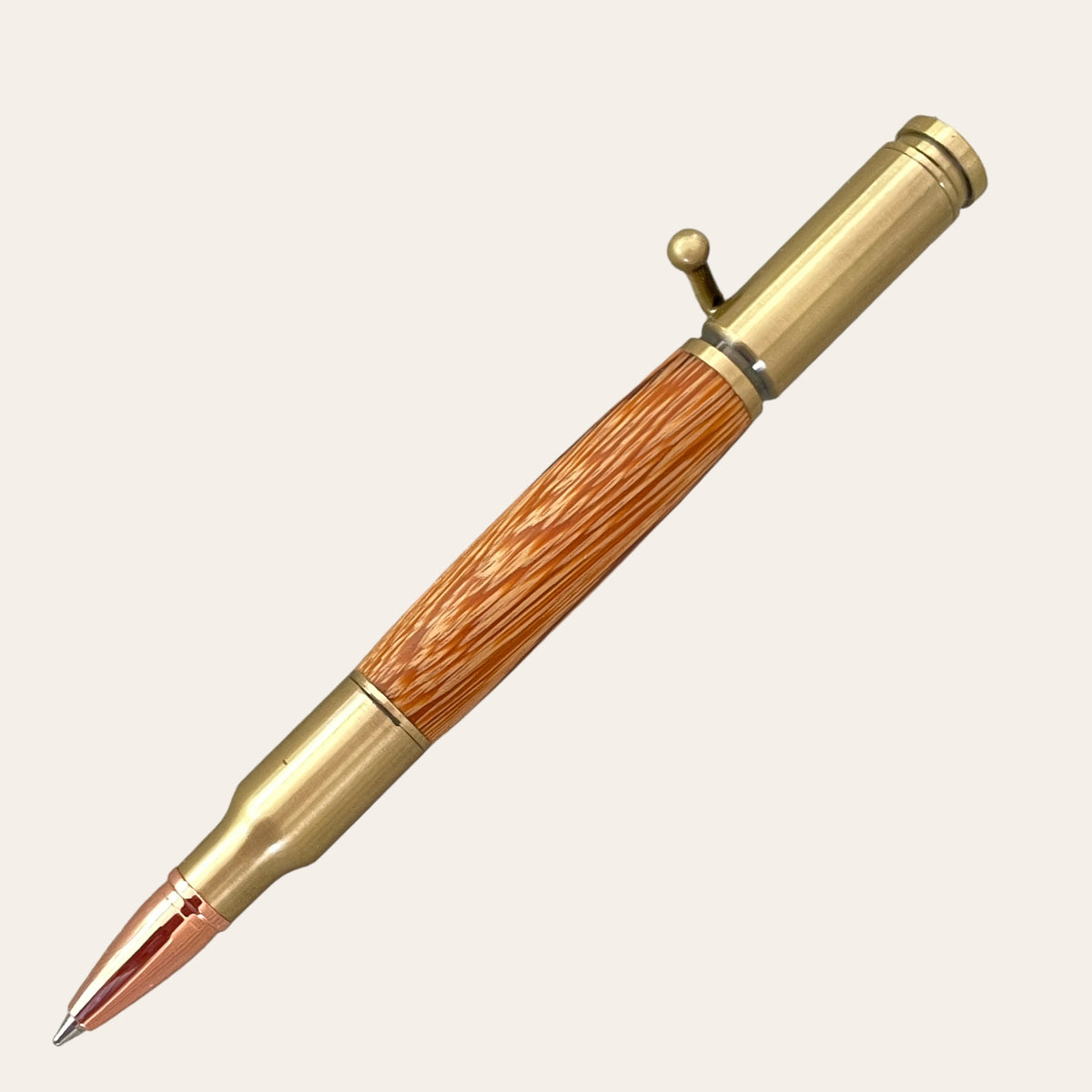 The 30 Caliber Rifle Bolt Action Pen with Antique Brass - Zebrawood by Paul's Hand Turned Creations is a handcrafted, stylized pen designed to resemble a rifle cartridge. It features a warm Zebrawood central grip, metallic accents, and an upper bolt-action mechanism for retracting the Parker style refill. The color scheme elegantly blends antique brass and wood tones.