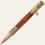 Introducing the Statue Of Liberty Bolt Action Hand Turned Pen - Bocote Wood from Paul's Hand Turned Creations: This patriotic writing tool boasts intricate details, with a wooden body and metallic accents. The clip is adorned with an American flag and an eagle. Other embellishments include the Statue of Liberty and a copper-toned tip, all beautifully harmonized in an antique brass finish.