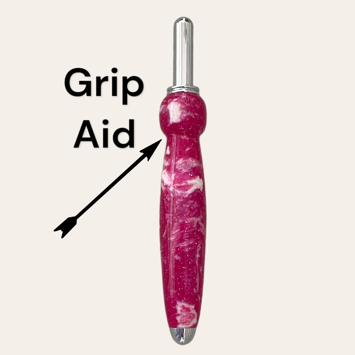 A Magenta Resin Single Blade Seam Ripper from Paul's Hand Turned Creations, exhibiting a maroon-colored design with a white marbled pattern and a cylindrical metallic tip at the top. An arrow points to the bulbous "Grip Aid" section, indicating the area designed for easier handling. This meticulously handmade seam ripper is set against a plain white background.