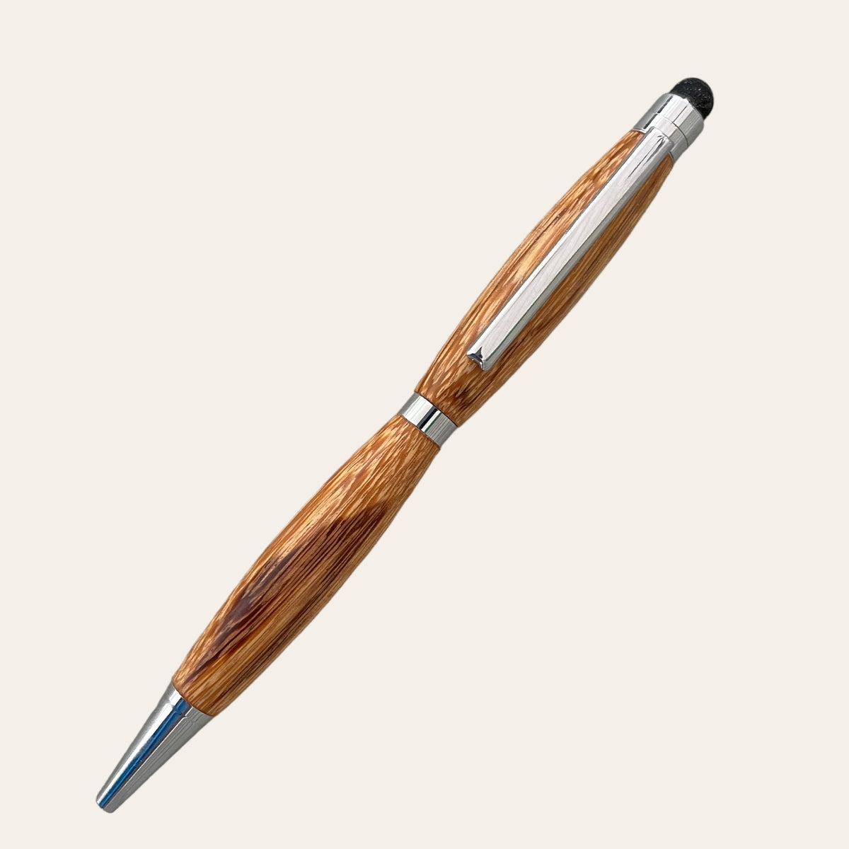 The Marblewood Refillable Stylus Pen with Chrome Trim by Paul's Hand Turned Creations is a handcrafted wooden pen featuring a polished finish, complete with a metal clip and tip. Its barrel showcases intricate wood grain patterns, highlighting its natural aesthetic. Additionally, this handmade stylus pen includes a stylus for touch screens at the end opposite the tip.