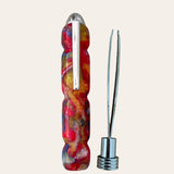 The Hand Turned Resin Case With Tweezer - Psychedelic by Paul’s Hand Turned Creations is a colorful multi-tool featuring a vibrant handle with shades of red, yellow, blue, and white marbling crafted from psychedelic resin. It includes a metallic clip on its side and a detachable bottom that reveals stainless steel tweezers. The background is plain light beige.