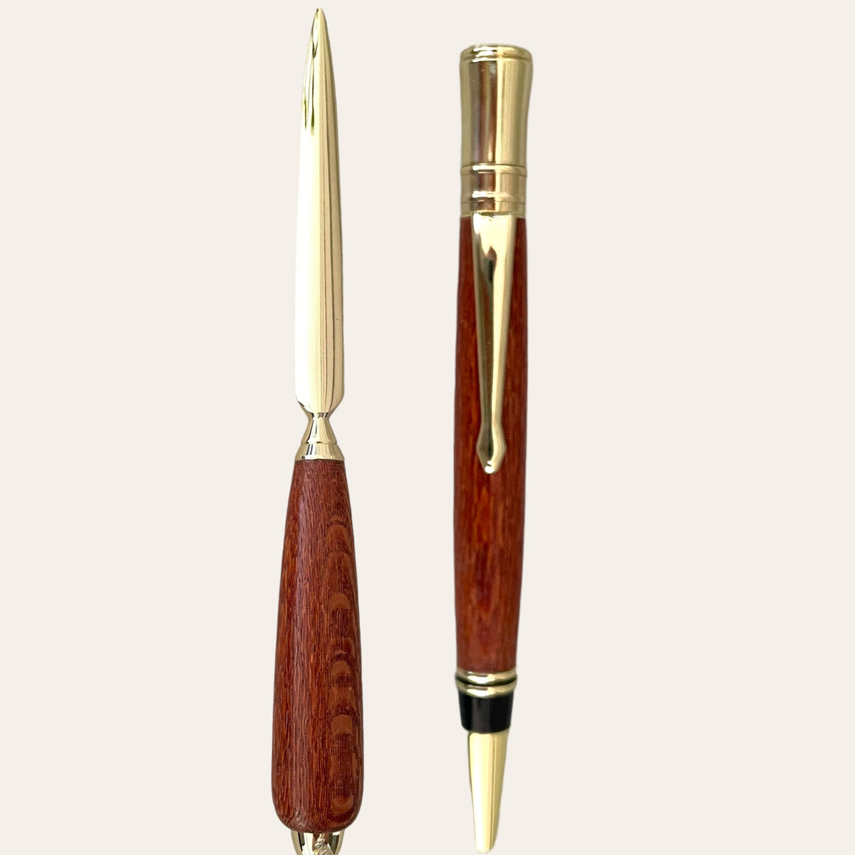 A sleek executive pen from Paul's Hand Turned Creations featuring a glossy Leopardwood barrel with a reddish-brown hue and gold-colored accents, including the clip, nib, and end cap, against a plain, light background. This exquisite writing instrument is part of their Letter Opener with Executive Pen on Gold Trim collection in exotic Leopard Wood.