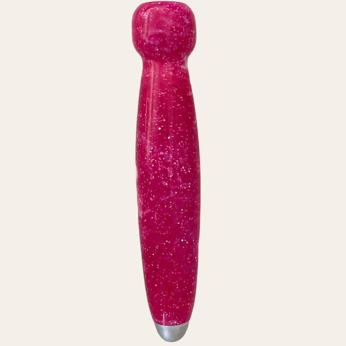 A magenta, cylindrical handle with a rounded top and glittery surface. It tapers slightly towards the base, which features a small metallic tip. This elegant piece is part of the Hand Turned Resin Crochet Handle with Nine Interchangeable Hooks set from Paul's Hand Turned Creations, perfect for your knitting projects. The background is plain white.
