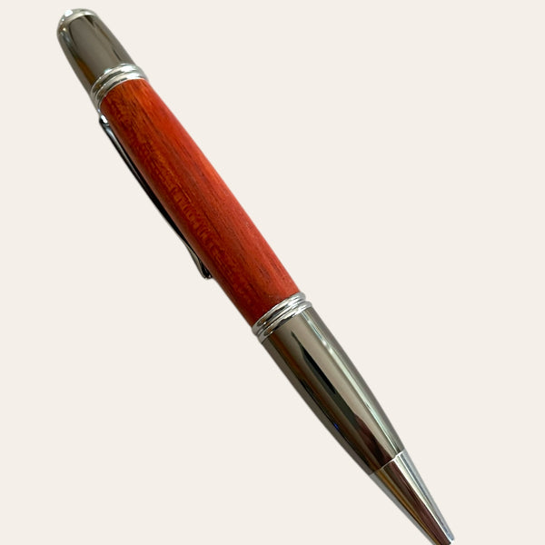 Paul's Gatsby Padauk pen with gun metal trim and clip, on a light background.