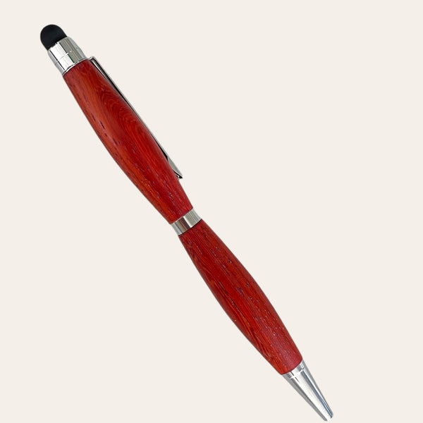 The Padauk Wood Refillable Stylus Pen Chrome Trim by Paul's Hand Turned Creations is a red, lathe-turned wooden pen. It has a metallic tip and clip, and features a black stylus on the opposite end. This handmade pen boasts silver accents and an ergonomic design for smooth writing. The photo backdrop is plain off-white.