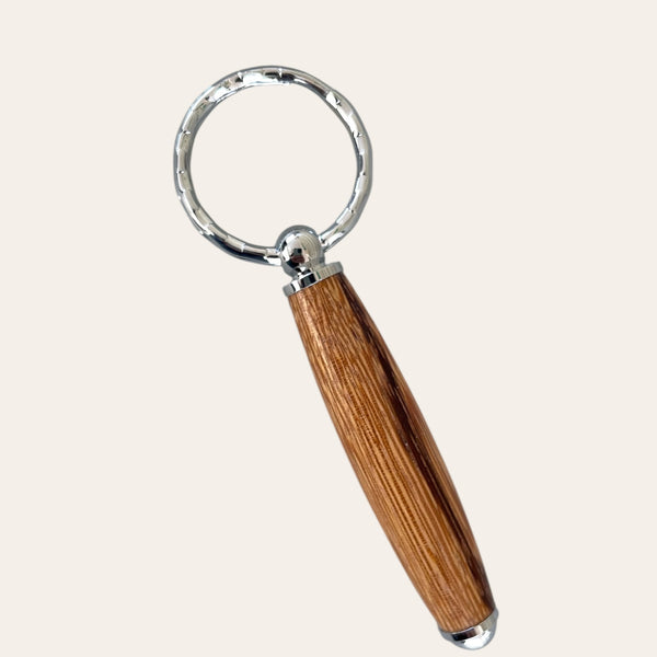 Zebrawood Small Keychain by Paul's Hand Turned Creations with circular silver top on plain backdrop.